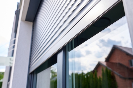 Close-up of a silver roller shutter door fitted above a modern property entrance.