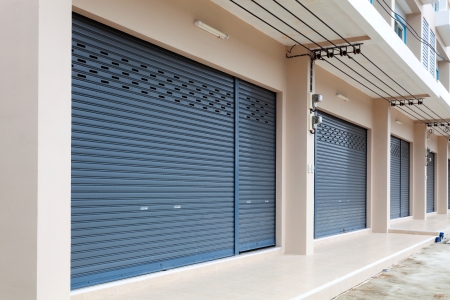 Commercial roller shutter doors securing multiple entrances along a business property.