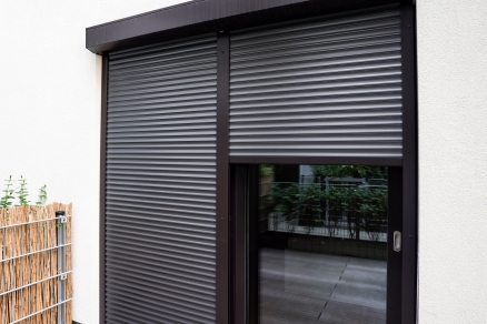 Insulated roller shutter doors fitted over a window to improve energy efficiency, retain heat and reduce draughts.
