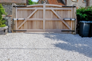 Traditional wooden home electric gates with automated swing gate motors, providing privacy, security and rustic kerb appeal for a residential gravel driveway. Is this conversation helpful so far?